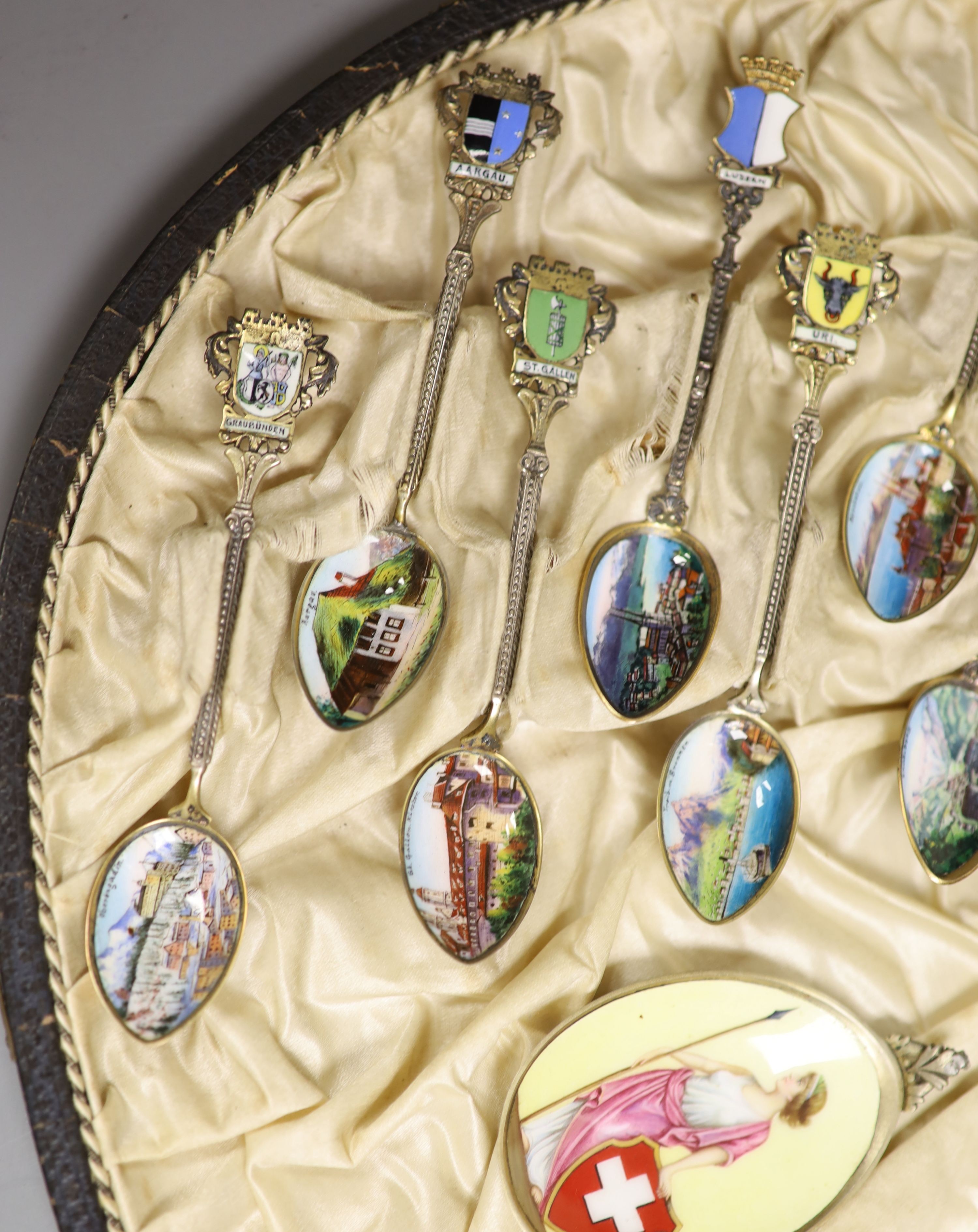 A set of 22 Swiss 800 silver and enamel souvenir spoons, each representative of a Canton, cased, with a larger spoon.